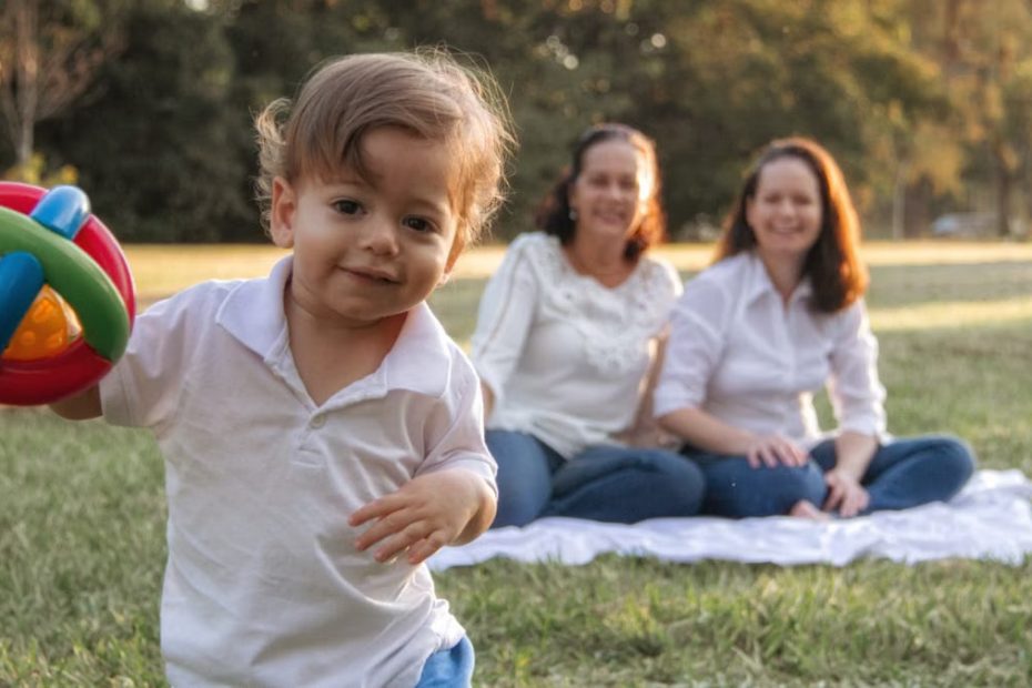 A joyful family enjoying a picnic in the park with a playful toddler in the foreground.